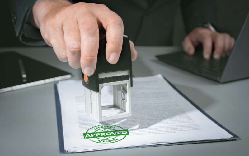 hands-businessman-stamp-paper-document-approve-business-investment-contract-agreement-closeup-person-hand-stamping-with-approved-stamp-document-desk-min (1)